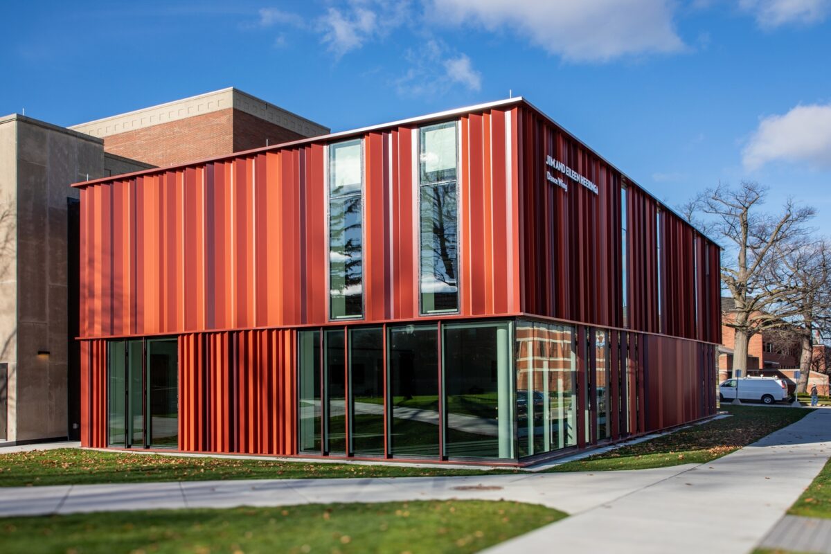 Exterior view of a dance studio featuring warm-toned panels and glass